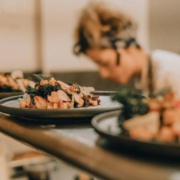 Köche haben Essen auf Tellern angerichtet, das zur Abholung bereit steht
