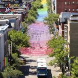 Ein Viertel in Montreal,geschmückt mit bunten Gierlanden und im Hintergrund die Skyline.