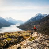 Frau steht auf einem Felsen und sieht auf einen See im Waterton Lakes National Park 